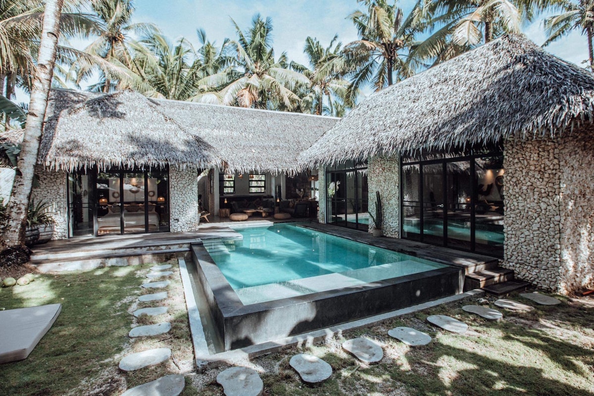 Villa Tulua Villa 1 exterior with private pool and thatched roof among palm trees