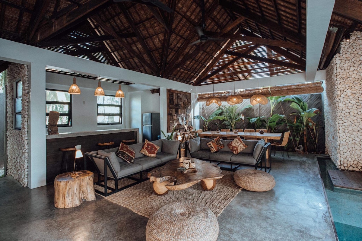 Villa Tulua open-air living room with thatched roof and curated Filipino-Balinese furnishings