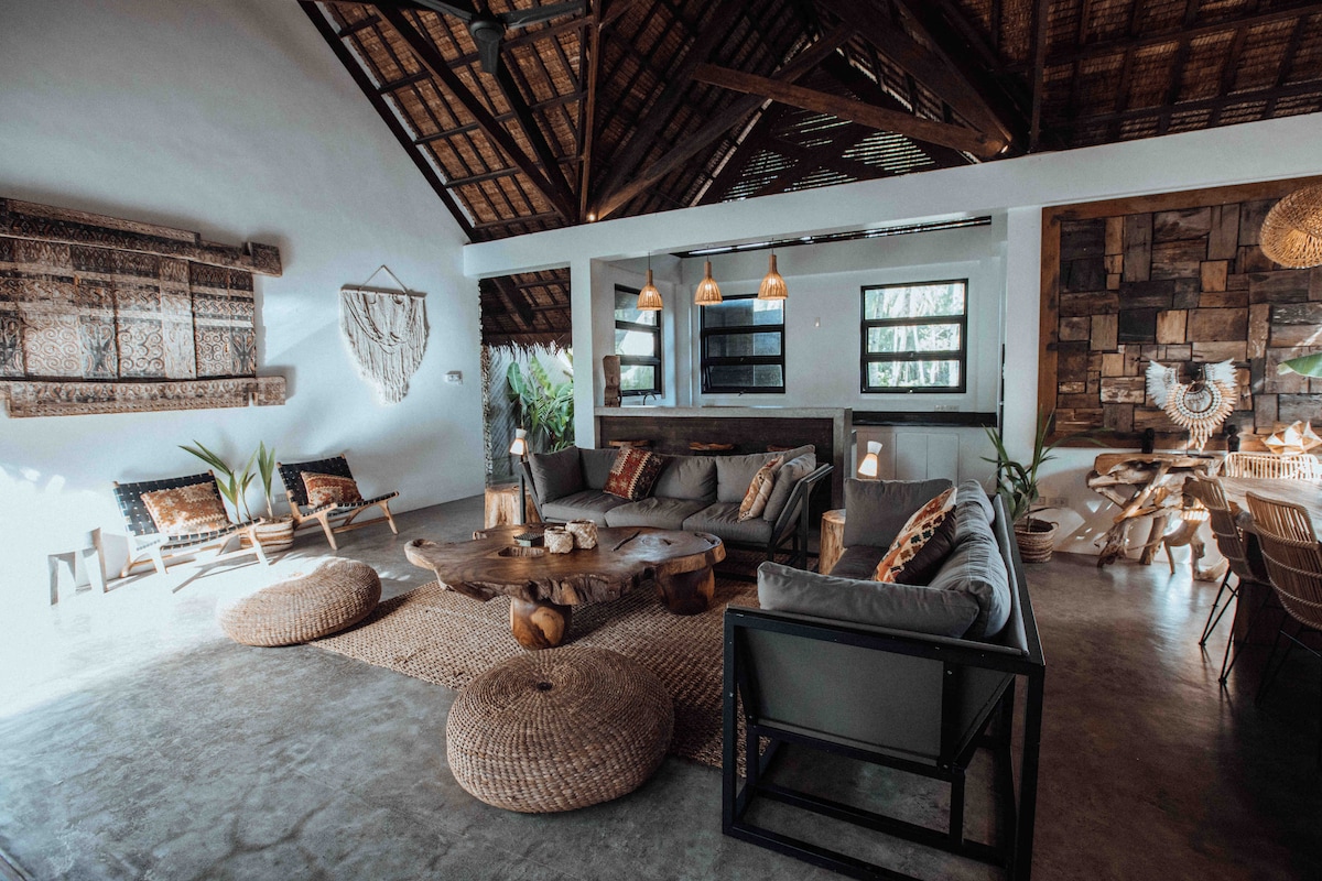 Living area with bohemian decor, woven textiles, and macrame wall hangings