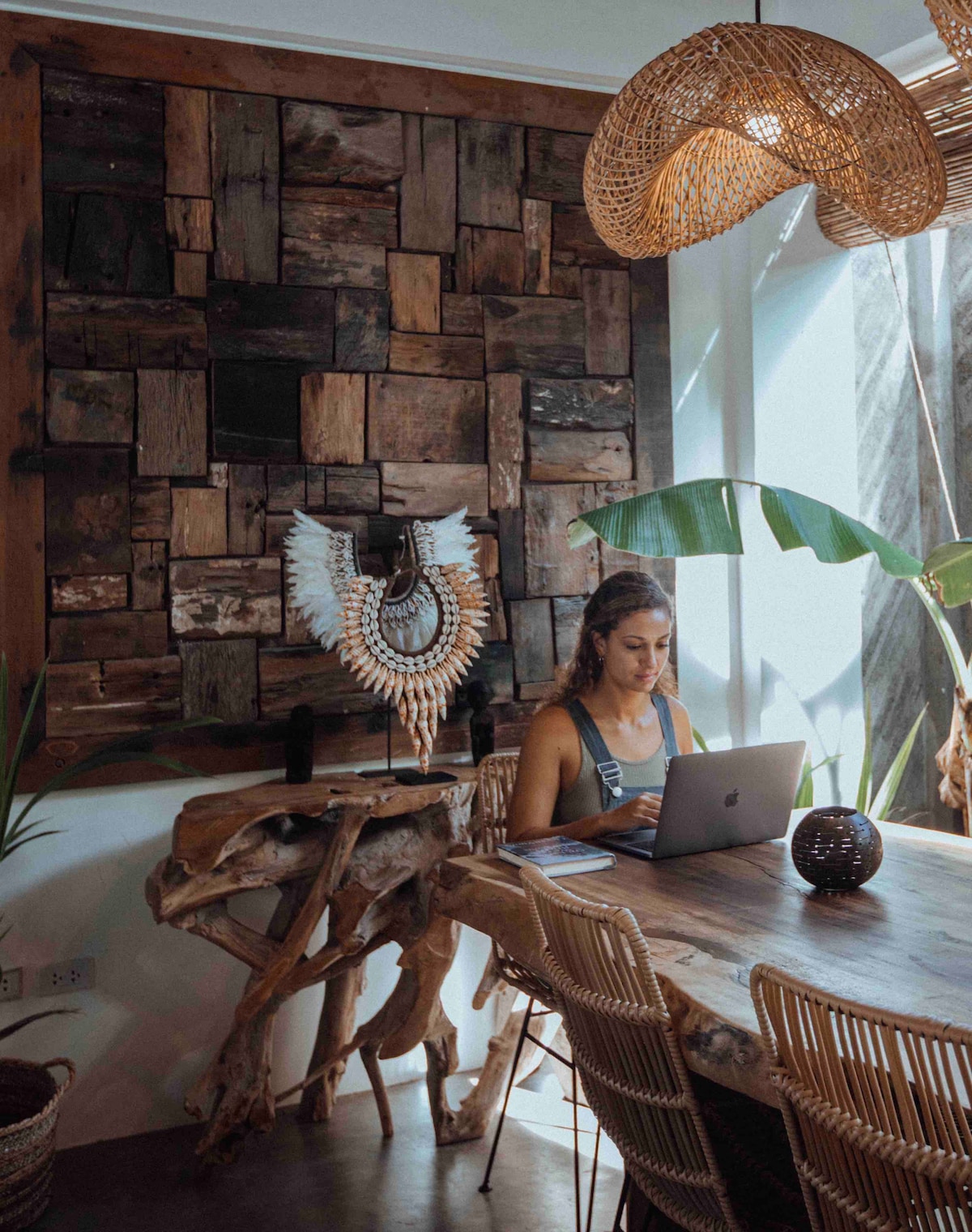Guest enjoying the villa's curated workspace with reclaimed wood accent wall